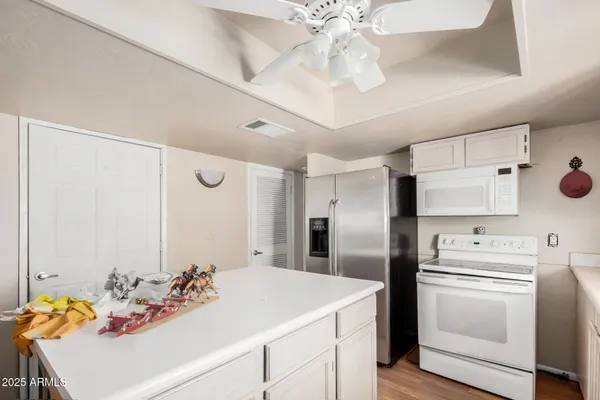 a kitchen with stainless steel appliances kitchen island granite countertop a sink and dishwasher with white cabinets