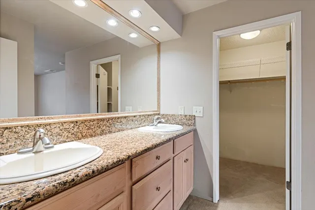 a bathroom with a granite countertop sink and a mirror