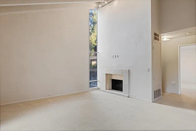 a view of empty room with a fireplace
