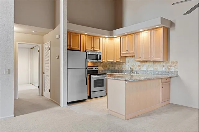 a kitchen with stainless steel appliances granite countertop a refrigerator and a sink