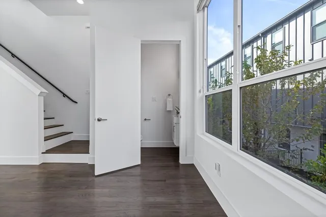 a view of a hallway with wooden floor and staircase