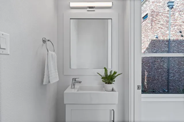 a bathroom with a sink a toilet and a window