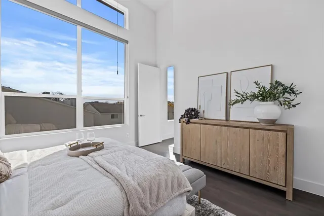 a bedroom with a large bed and a potted plant