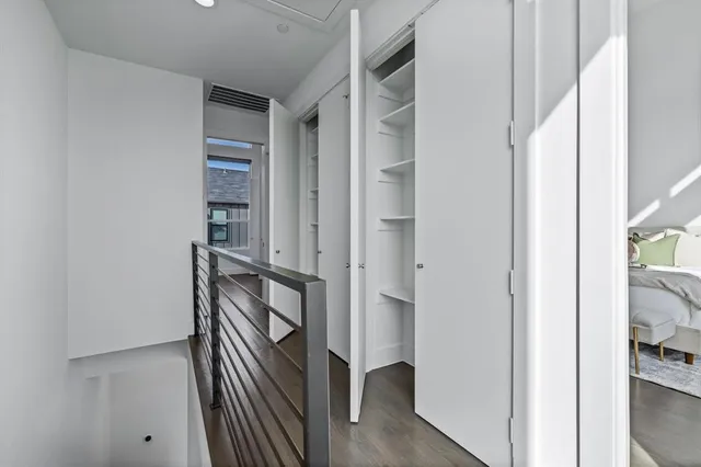 a view of a hallway with closet and wooden floor