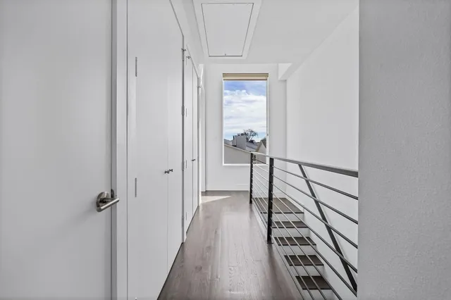 a view of a hallway with wooden floor and staircase