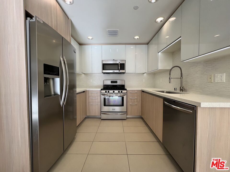 11715 Bellagio Road, Unit 305 Los Angeles, CA 90049 - Photo 5 of 25 a kitchen with a refrigerator sink and microwave