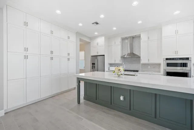 a kitchen with stainless steel appliances granite countertop a sink a stove and a refrigerator