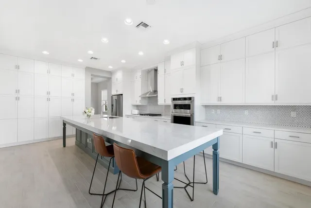 a kitchen with kitchen island a table and chairs in it