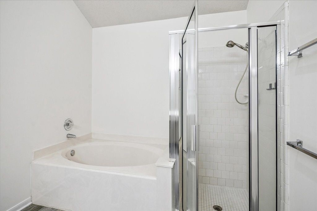 143 West Village Knoll Circle Spring, TX 77381 - Photo 18 of 27 The spacious layout of the primary bathroom suite offers both comfort and functionality. With generous space between the soaking tub, walk-in shower, and dual vanities, you’ll enjoy plenty of room to move freely and get ready with ease. Designed for both relaxation and practicality, this open layout brings a sense of luxury to your daily routine.