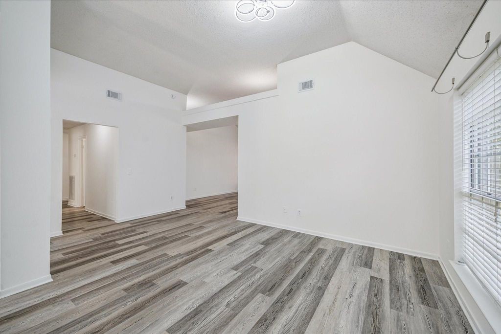 143 West Village Knoll Circle Spring, TX 77381 - Photo 6 of 27 This bright and versatile room, located just off the family/living area, features vaulted ceilings, modern wood-look flooring, and a large window that fills the space with natural light—perfect for a home office, formal dining area, or cozy reading nook.