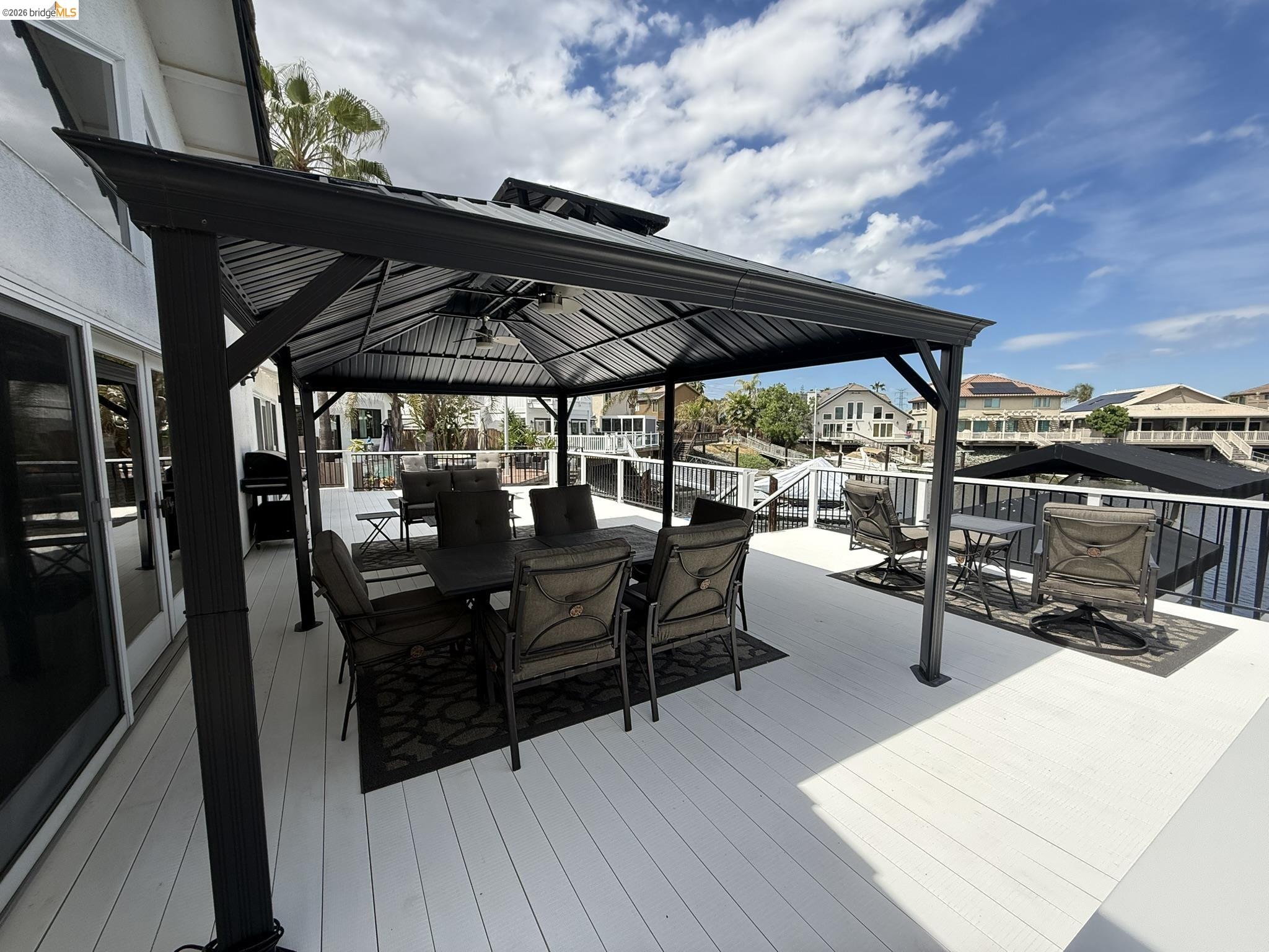 91 Shell Place Discovery Bay, CA 94505 - Photo 31 of 39 a view of a patio with table and chairs under an umbrella with wooden floor