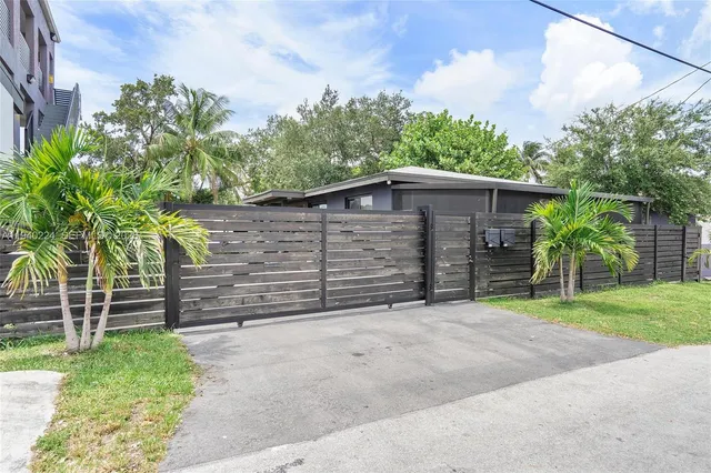 a backyard of a house with plants and tree