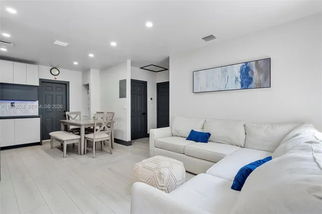a living room with furniture and kitchen view