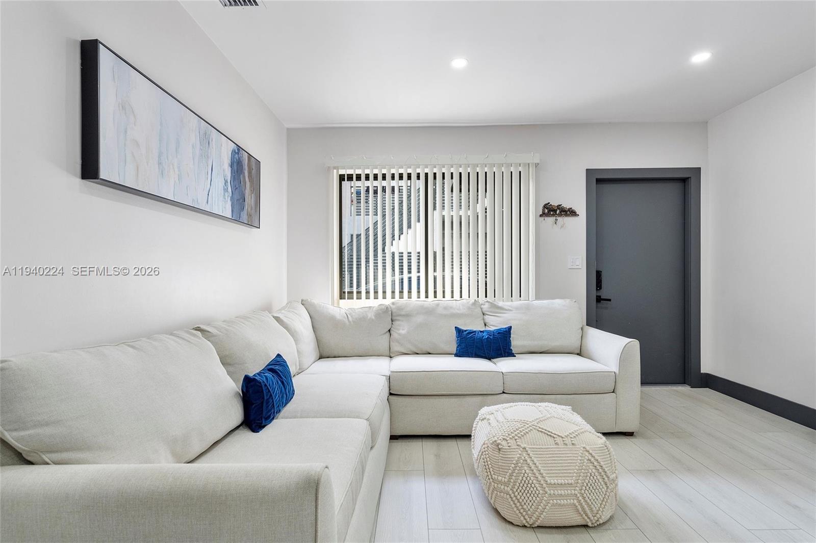 100 Northeast 71st Street, Unit 100 Miami, FL 33138 - Photo 6 of 15 a living room with furniture and a large window