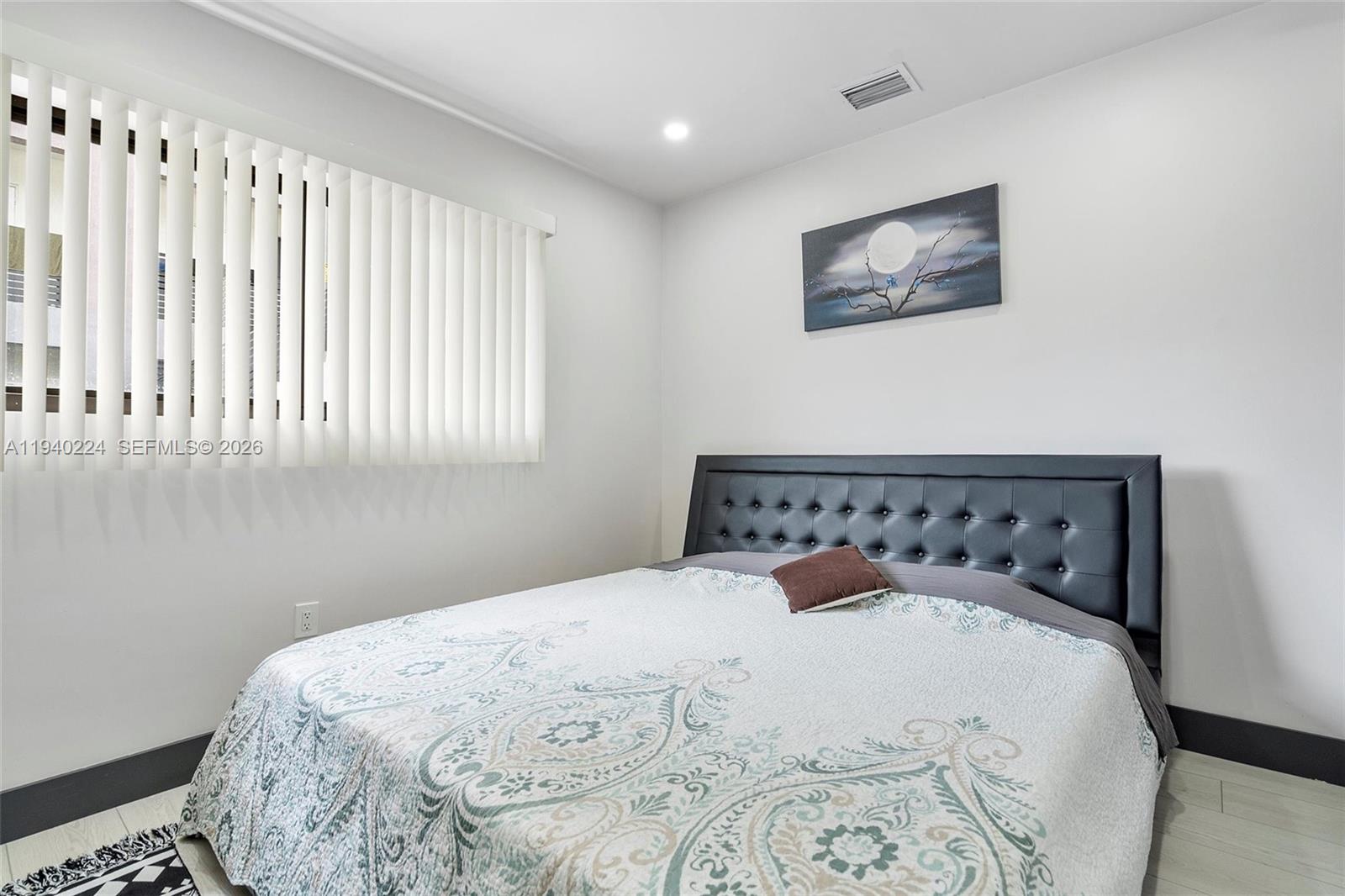 100 Northeast 71st Street, Unit 100 Miami, FL 33138 - Photo 7 of 15 a large bed sitting in a bedroom next to a window
