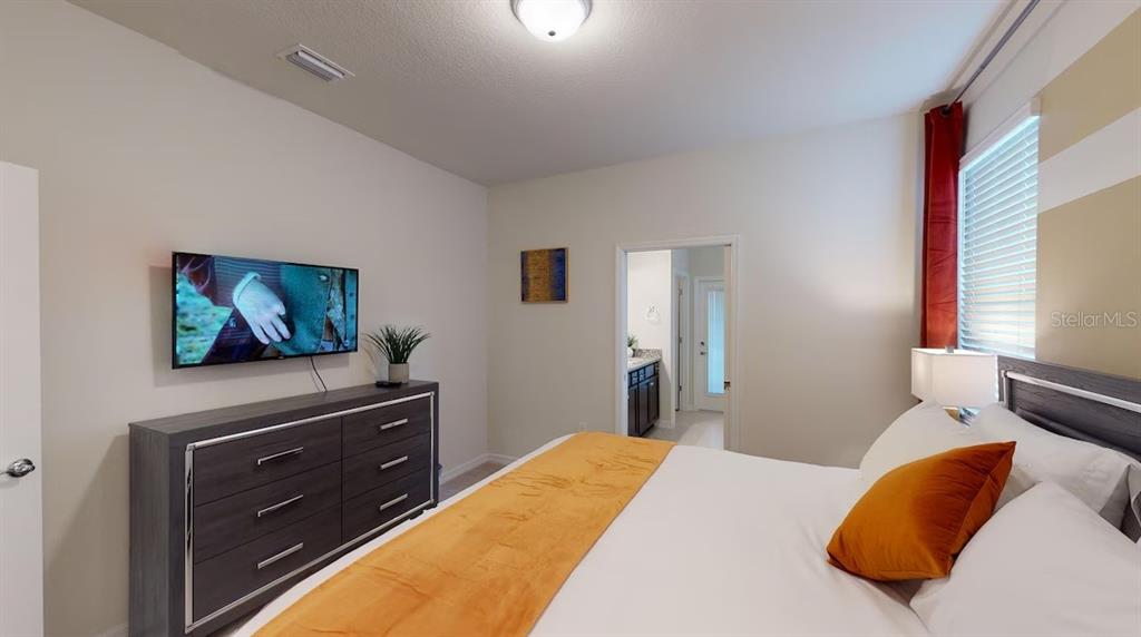 2479 Dubai Street Kissimmee, FL 34747 - Photo 12 of 70 a bedroom with a bed and a flat screen tv