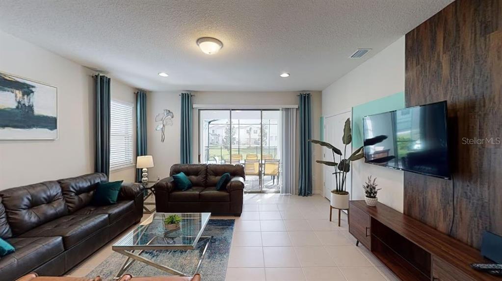 2479 Dubai Street Kissimmee, FL 34747 - Photo 15 of 70 a living room with furniture a flat screen tv and a large window