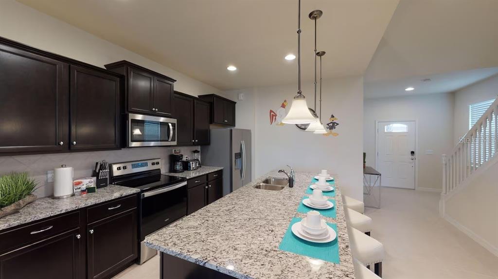 2479 Dubai Street Kissimmee, FL 34747 - Photo 16 of 70 a kitchen with stainless steel appliances granite countertop a stove top oven a refrigerator a sink and dishwasher