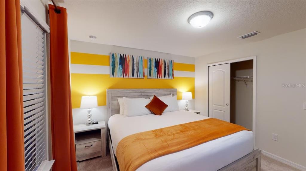 2479 Dubai Street Kissimmee, FL 34747 - Photo 21 of 70 a bedroom with a bed and a painting on the wall