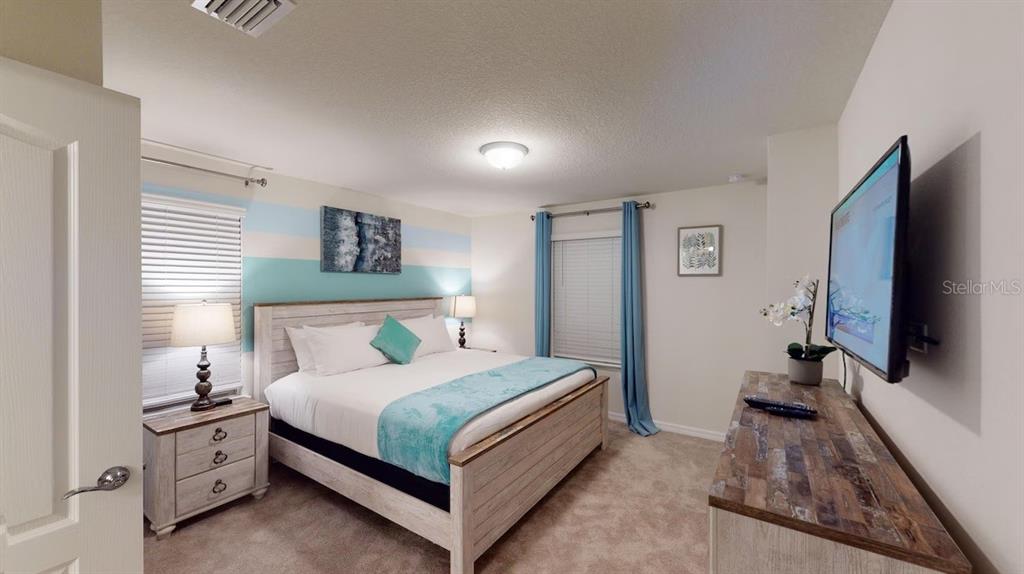 2479 Dubai Street Kissimmee, FL 34747 - Photo 23 of 70 a bedroom with a bed and a flat tv screen on dresser