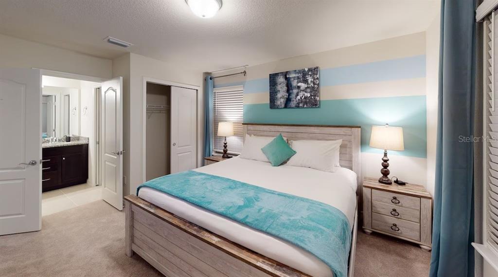 2479 Dubai Street Kissimmee, FL 34747 - Photo 24 of 70 a bedroom with a bed and a lamp on dresser