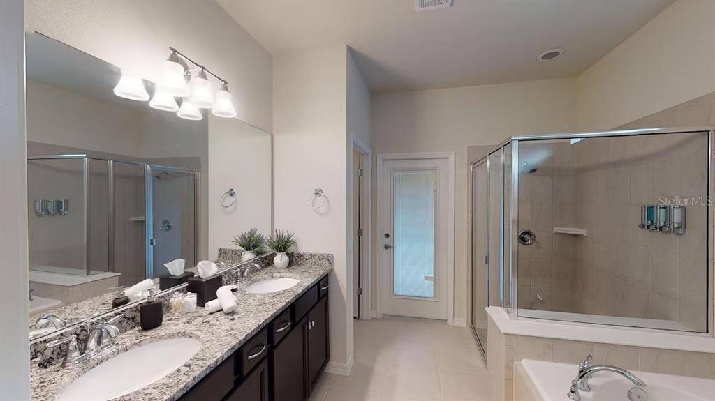 2479 Dubai Street Kissimmee, FL 34747 - Photo 26 of 70 a bathroom with a granite countertop shower sink and mirror
