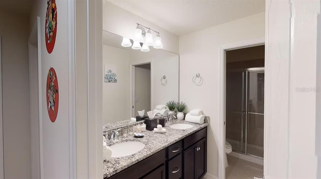 2479 Dubai Street Kissimmee, FL 34747 - Photo 31 of 70 a bathroom with a granite countertop sink and a mirror