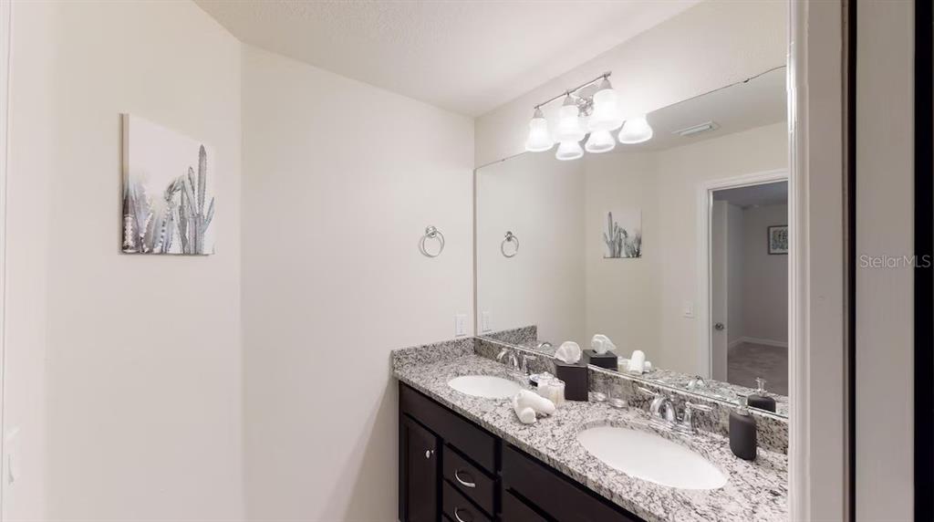 2479 Dubai Street Kissimmee, FL 34747 - Photo 33 of 70 a bathroom with a granite countertop sink and a mirror