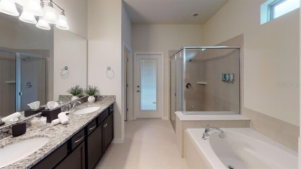 2479 Dubai Street Kissimmee, FL 34747 - Photo 34 of 70 a bathroom with a granite countertop tub sink and mirror