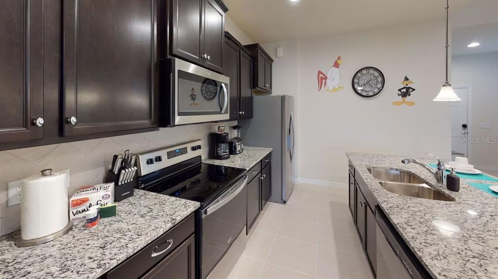 2479 Dubai Street Kissimmee, FL 34747 - Photo 36 of 70 a kitchen with granite countertop a sink a stove and cabinets
