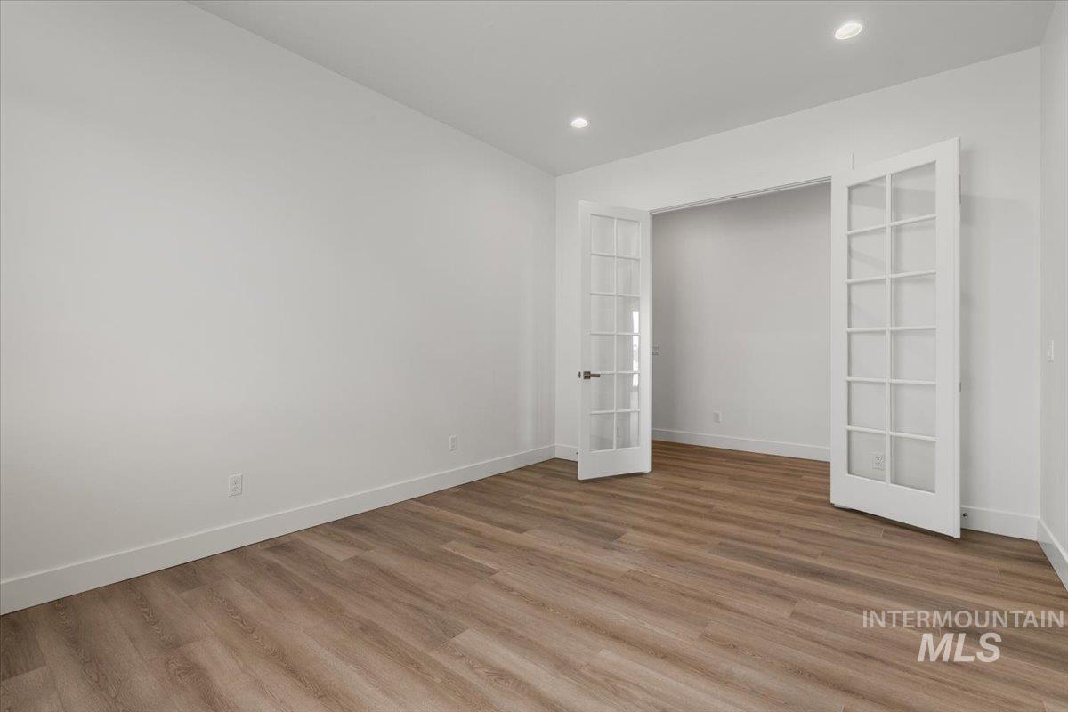 929 North Falling Water Way Eagle, ID 83616 - Photo 14 of 43 Unfurnished bedroom with french doors, light wood-style floors, and recessed lighting