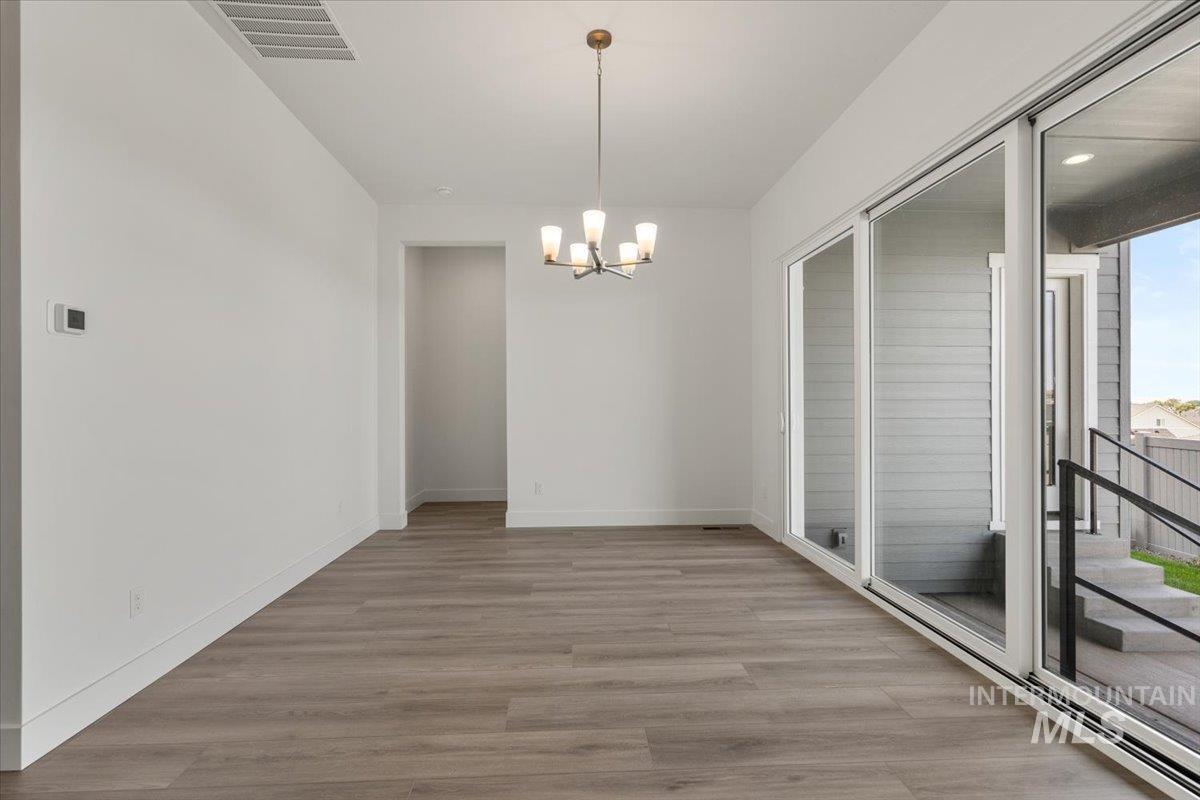 929 North Falling Water Way Eagle, ID 83616 - Photo 26 of 43 Unfurnished dining area with light wood-style flooring and a chandelier