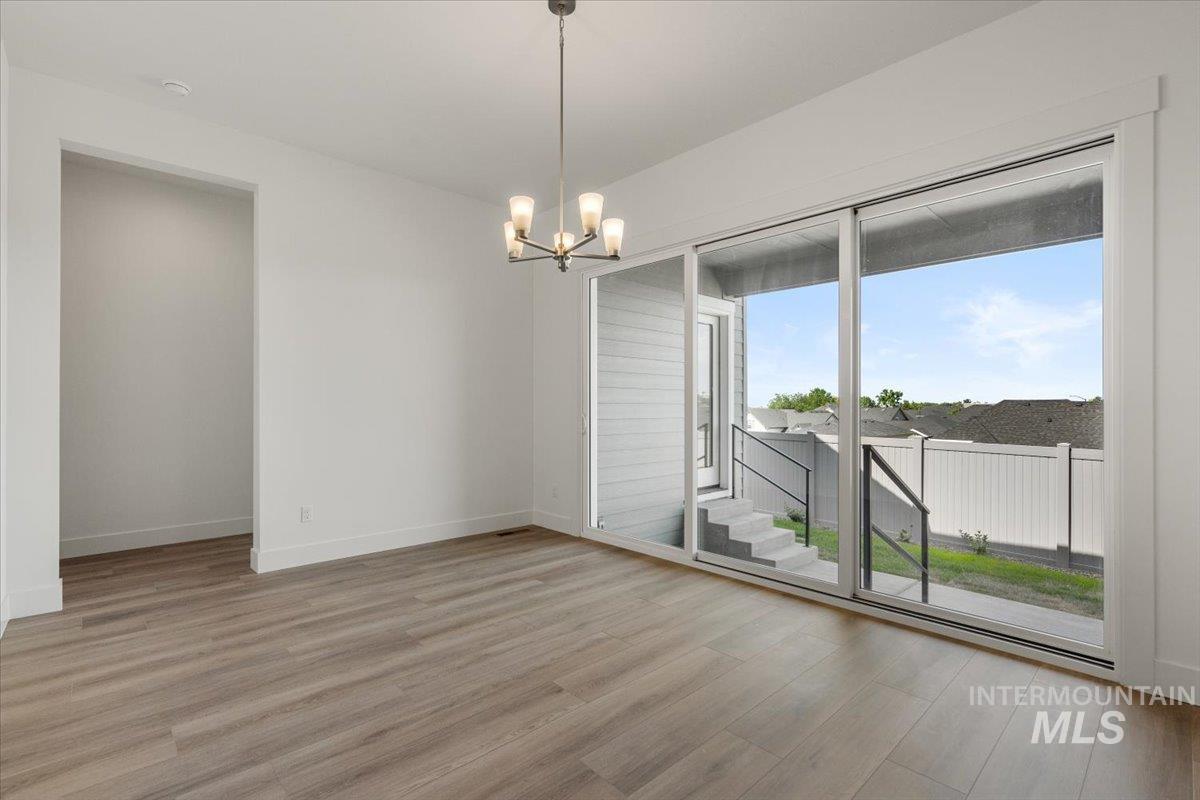 929 North Falling Water Way Eagle, ID 83616 - Photo 27 of 43 Unfurnished room with light wood-style flooring and a chandelier
