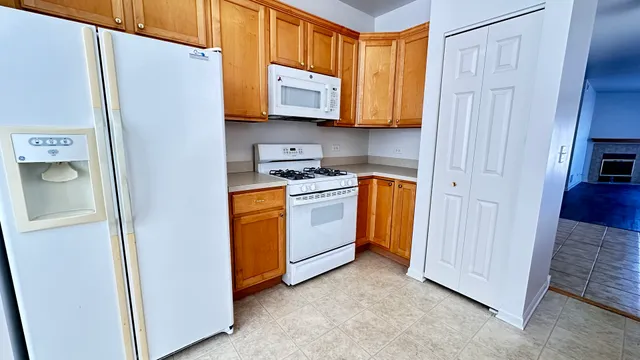 a kitchen with stainless steel appliances granite countertop a refrigerator a microwave a sink and dishwasher