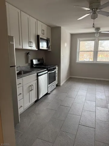 a kitchen with stainless steel appliances a sink a stove a microwave and cabinets