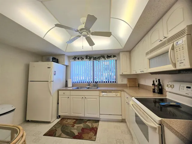 a kitchen with a sink a refrigerator a stove and cabinets