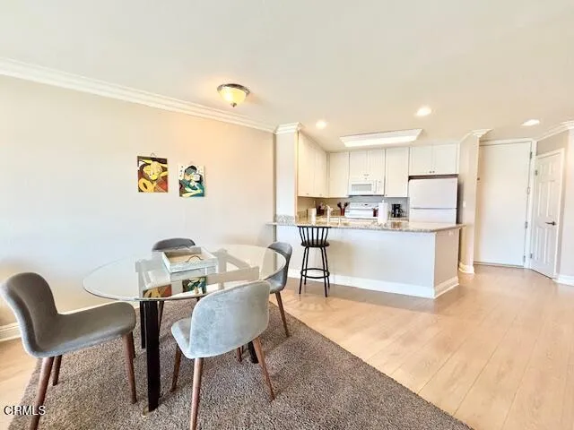 a living room with stainless steel appliances kitchen island granite countertop furniture and a dining table with wooden floor