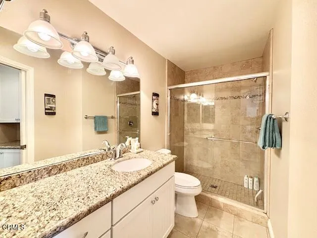 a bathroom with a granite countertop sink a toilet and a shower