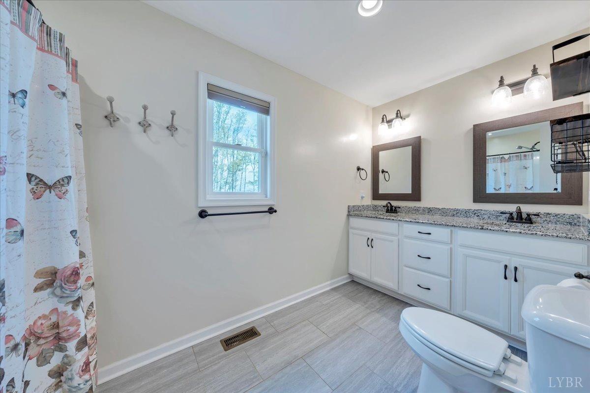 1400 Mountain Cut Road Appomattox, VA 24522 - Photo 15 of 55 a spacious bathroom with a granite countertop toilet a sink a mirror and a shower