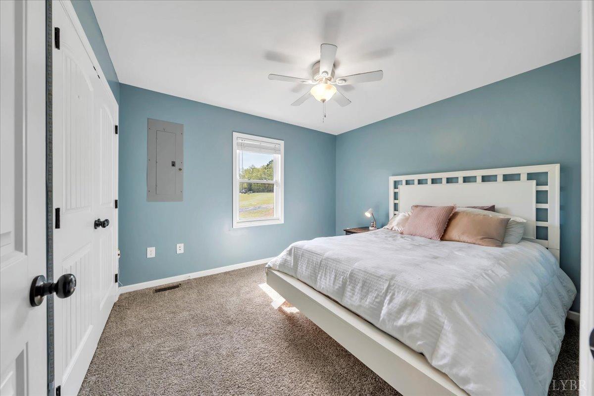 1400 Mountain Cut Road Appomattox, VA 24522 - Photo 21 of 55 a bedroom with a large bed and a chandelier