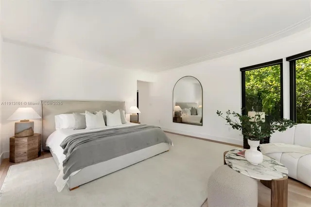 a bedroom with a balcony a bed and a potted plant