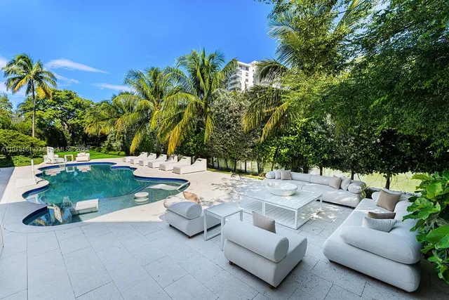 a view of a patio with couches and a table and chairs under an umbrella