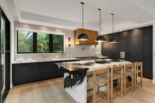 a kitchen with a stove a sink a table and chairs