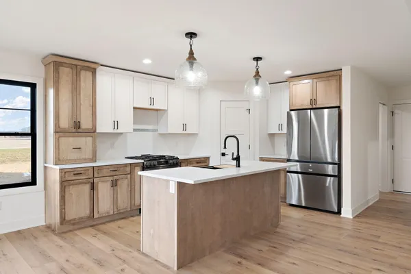 a kitchen with stainless steel appliances granite countertop a stove a sink and white cabinets