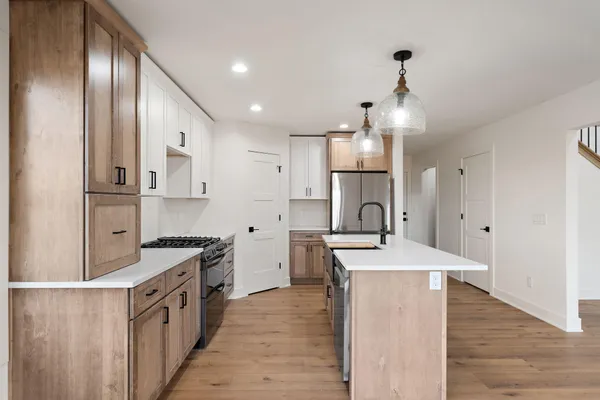 a kitchen with stainless steel appliances granite countertop a sink stove and refrigerator