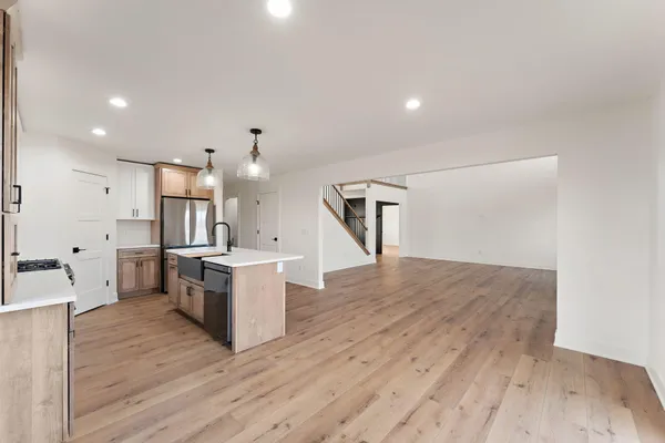 an empty room with wooden floor ceiling fan and windows