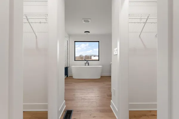 a view of a hallway with entryway and stairs