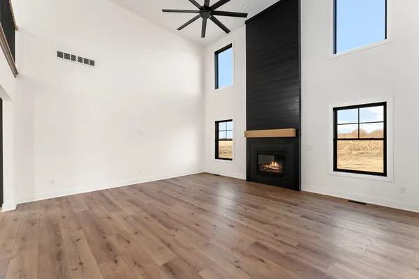 a view of an empty room with window and fire place