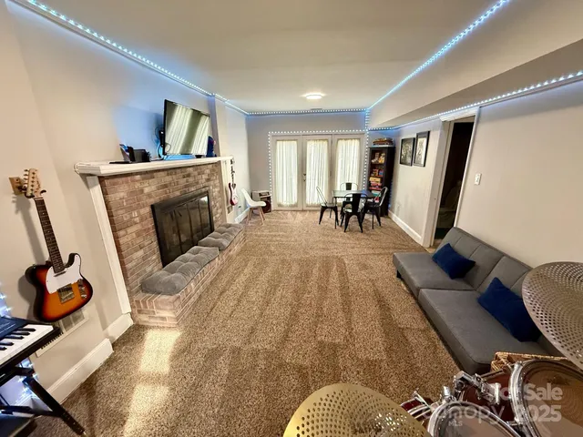 a living room with furniture a flat screen tv and a fireplace
