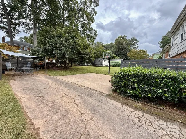 a view of backyard with swimming pool and seating space